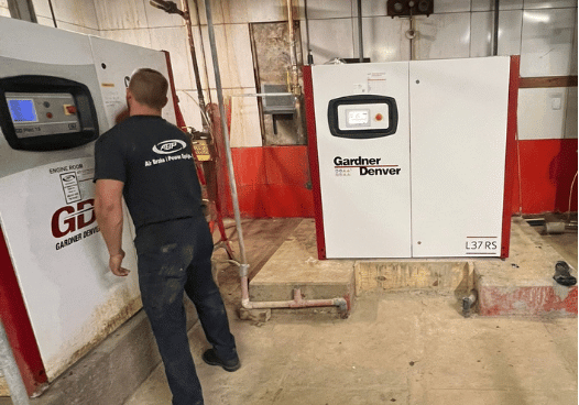 A man looking at the interactive screen on an air compressor system