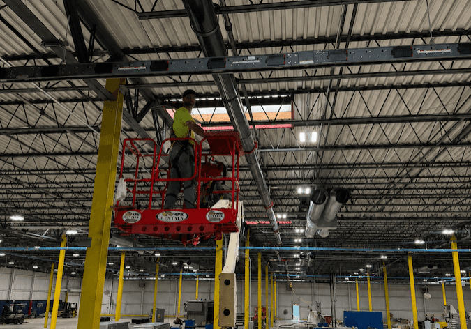 A man on a lift in a warehouse